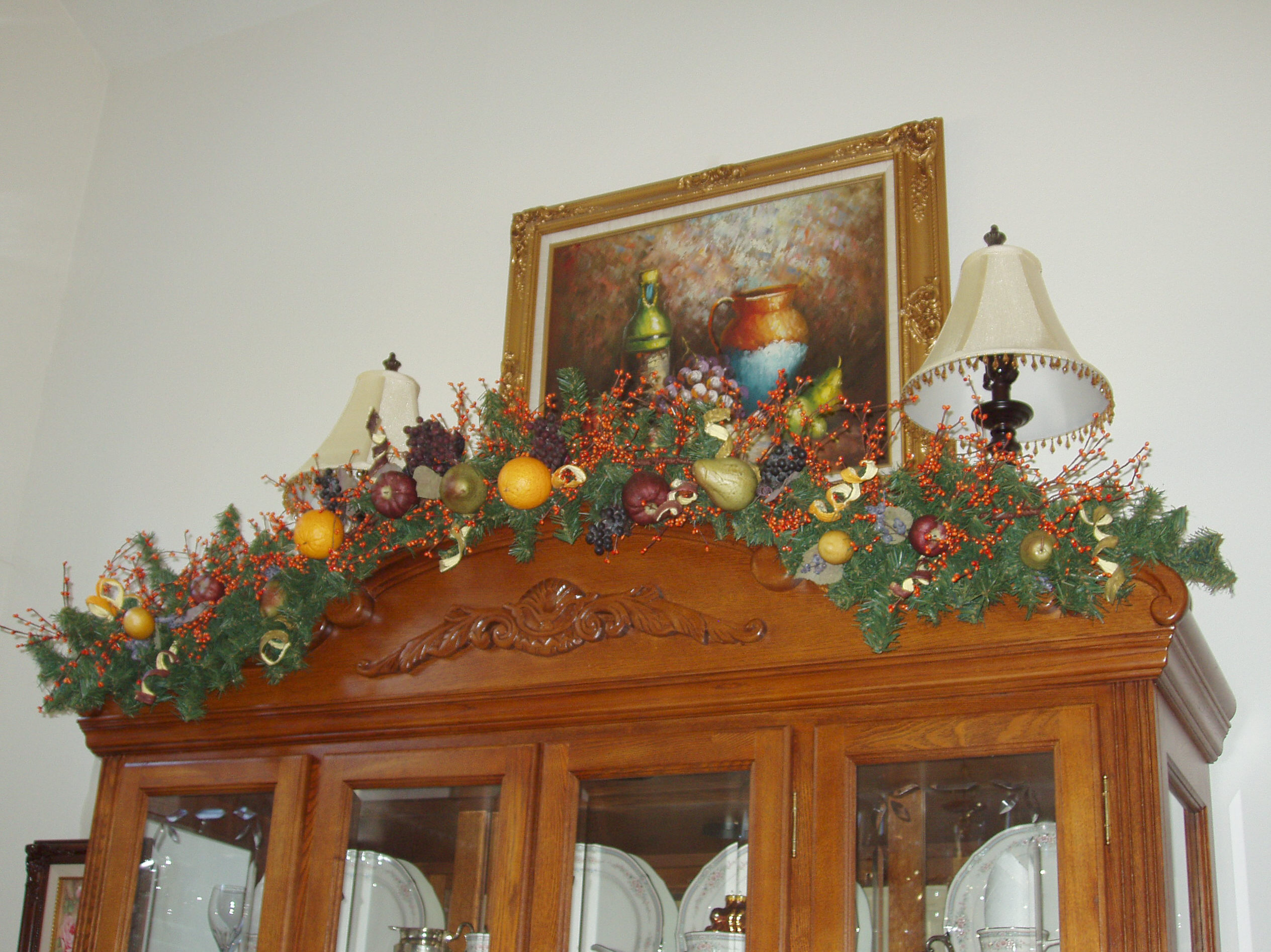 Decorating A China Cabinet With A Pine Garland For Christmas The